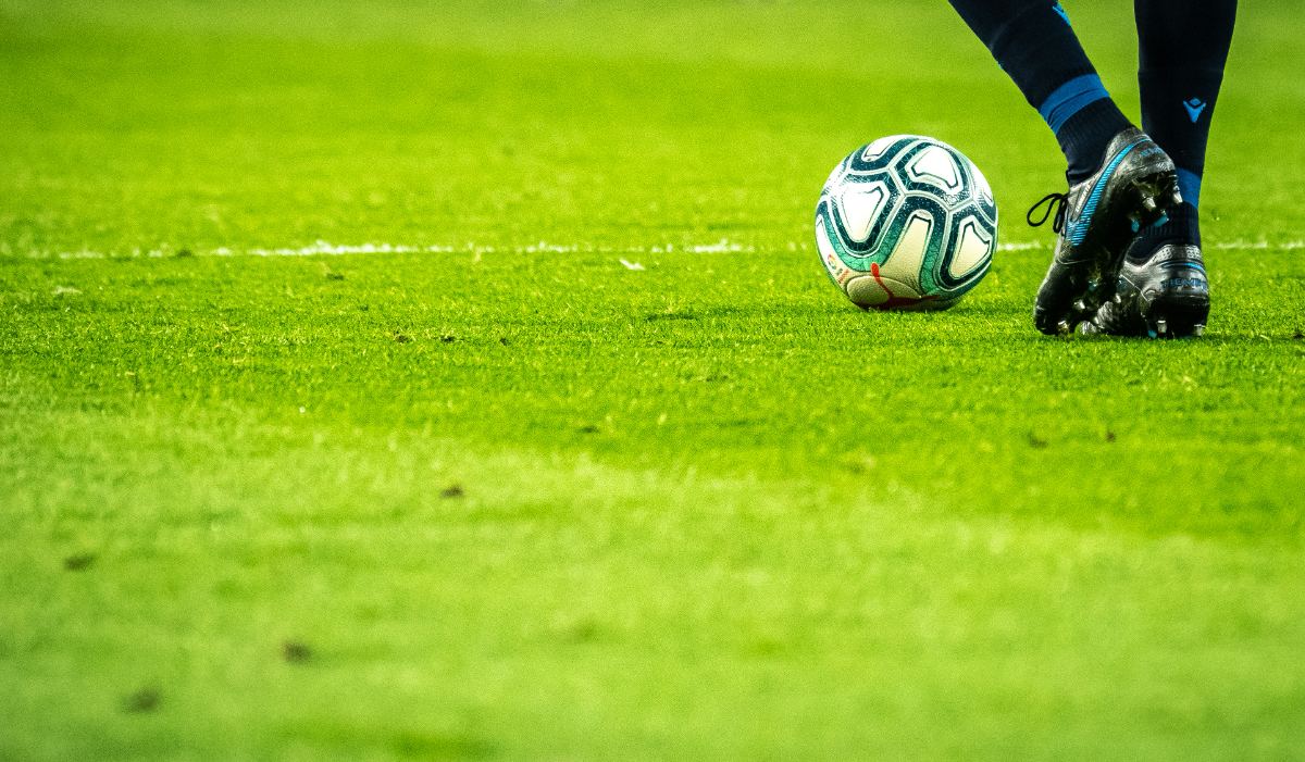 Footballer with the ball on grass
